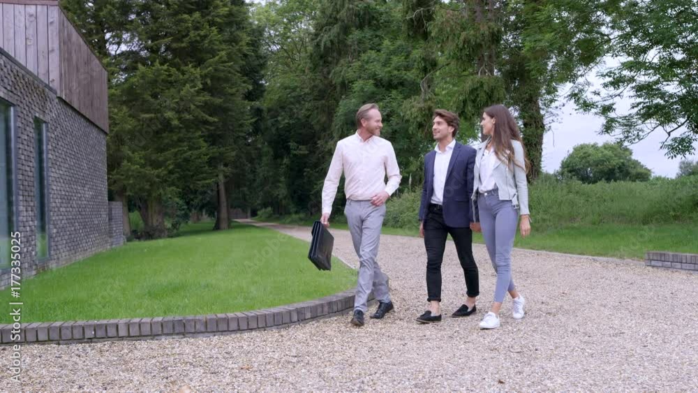 Happy couple with real estate agent, viewing modern home to buy or rent Happy couple with real estate agent, viewing modern home to buy or rent