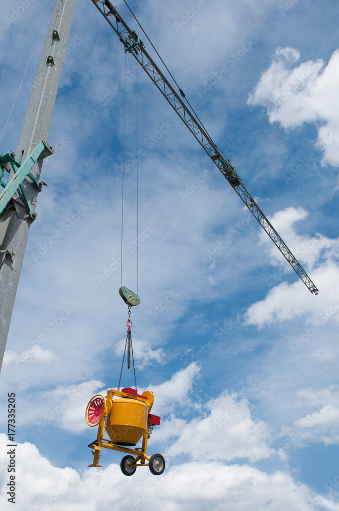 Construction crane lifting cement mixer