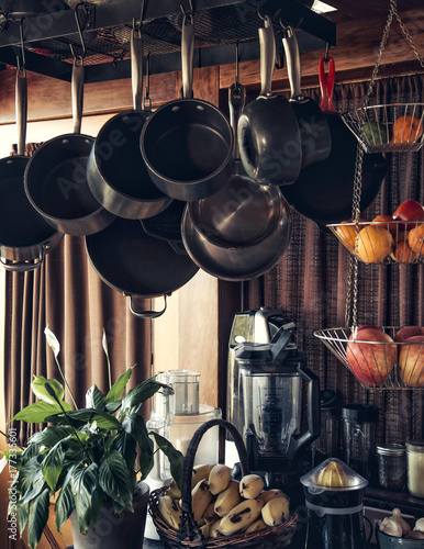 Pots and Pans hang in the kitchen with fruits and vegetables