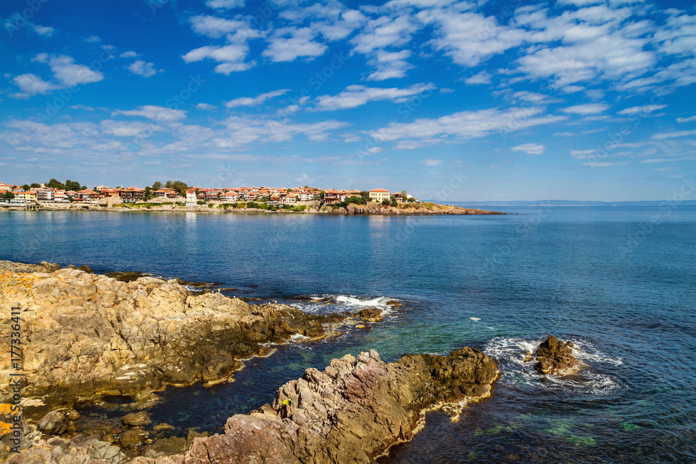 Coastal landscape - the rocky seashore with houses under the sky with clouds, town of Sozopol on the Black Sea coast in Bulgaria