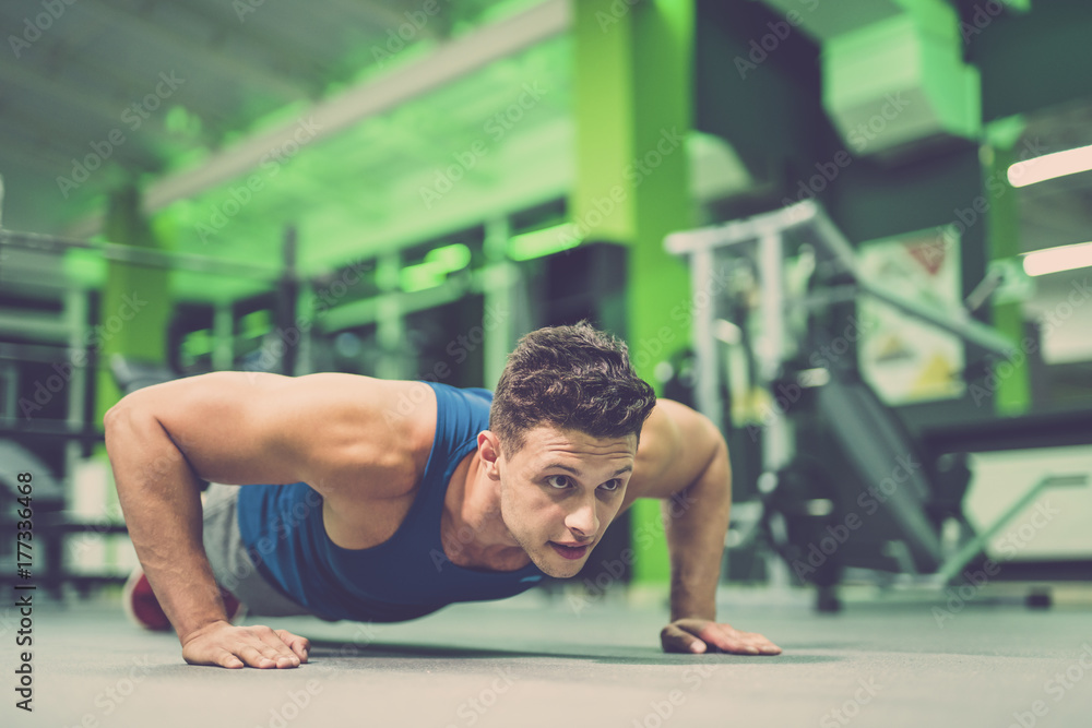 The sportsman doing push up exercise in the gym The sportsman doing push up exercise in the gym