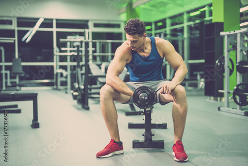 The sportsman doing exercise with a dumbbell in the fitness club © realstock1