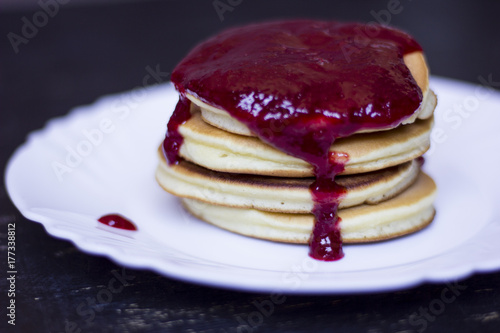 A perfect breakfast combo of jam, pancakes, and a hot cup of coffee.