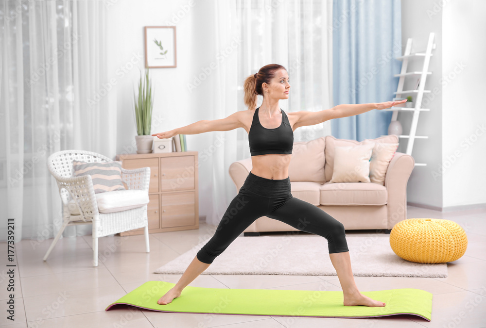 Fototapeta premium Young beautiful woman training at home