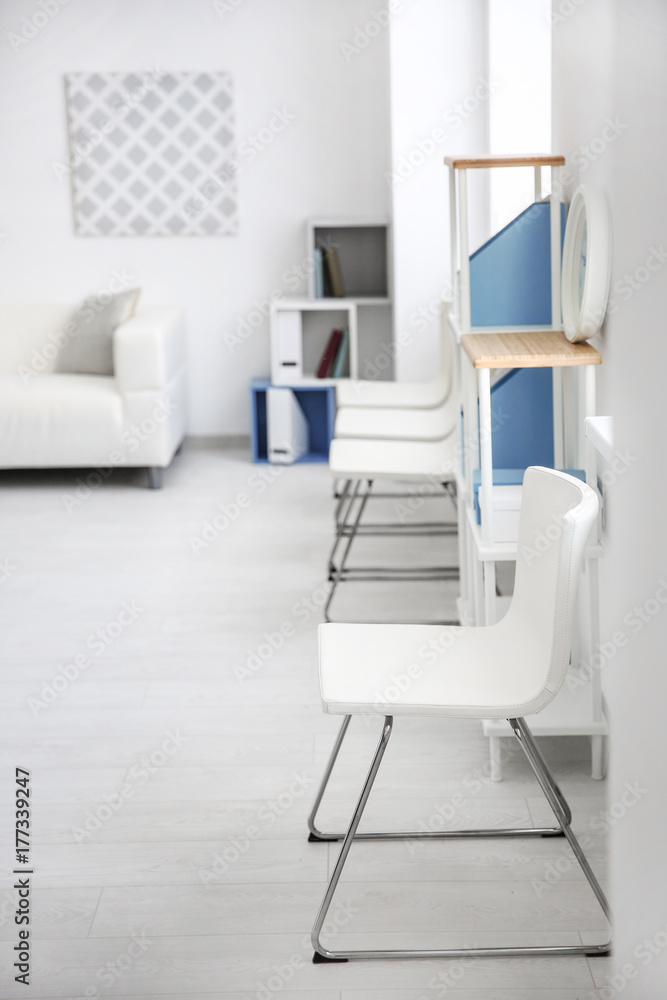 Modern room interior with white chairs and shelving unit