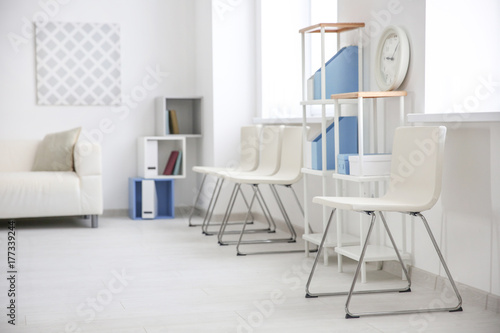 Modern room interior with white chairs and shelving unit © Africa Studio