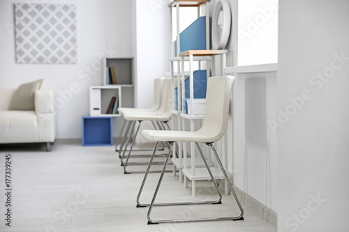 Modern room interior with white chairs and shelving unit © Africa Studio