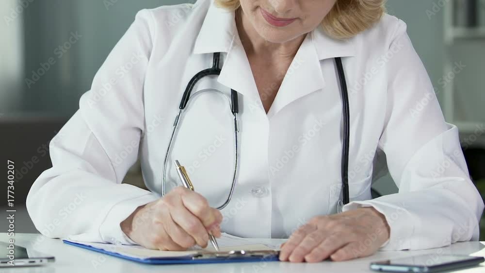 Female physician prescribing medication at clinic, professional doctor at work Female physician prescribing medication at clinic, professional doctor at work