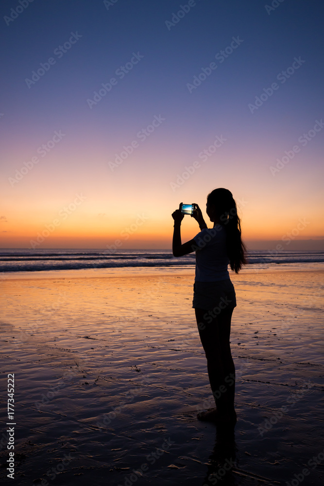 Silhouette of girl taking picture on phone