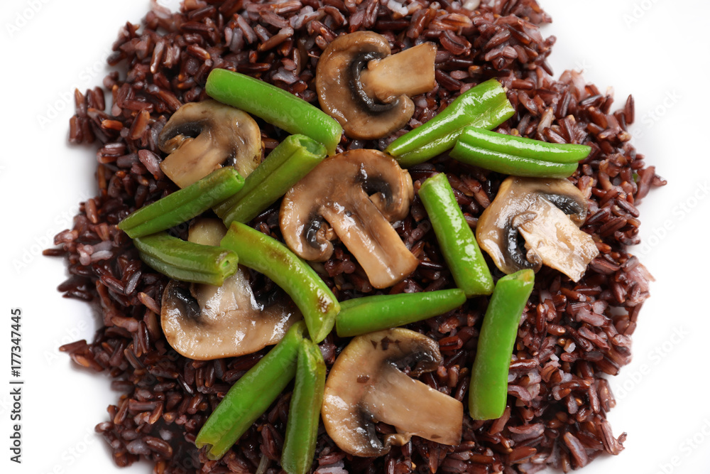 Red rice with mushrooms and green beans on white background, closeup Red rice with mushrooms and green beans on white background, closeup