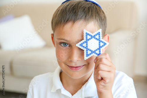 Boy holding Star of David at home photo