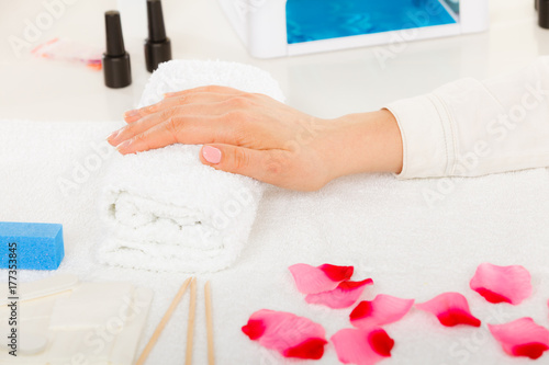 Woman hand on towel  next to manicure set