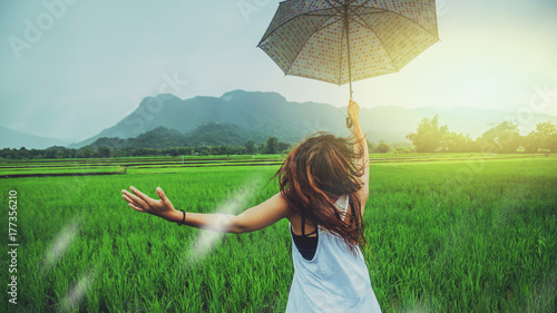 Asian women travel relax in the holiday. Women stand in rain umbrellas. On the meadow During the rainy season.Thailand