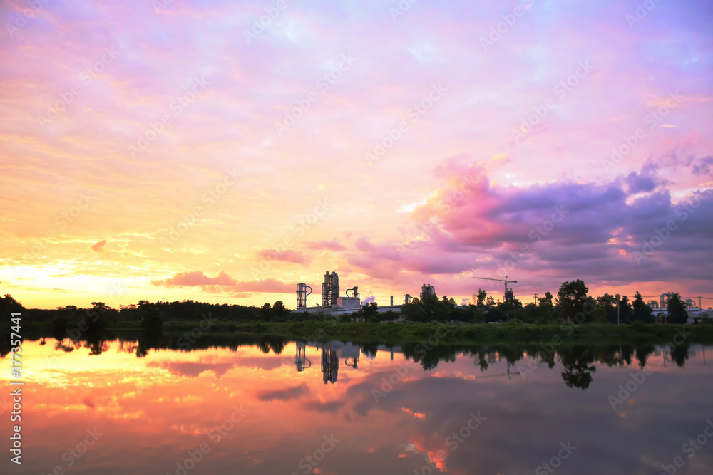 colorful sky and reflection looklike water color painted and silhouette factory in wild forest