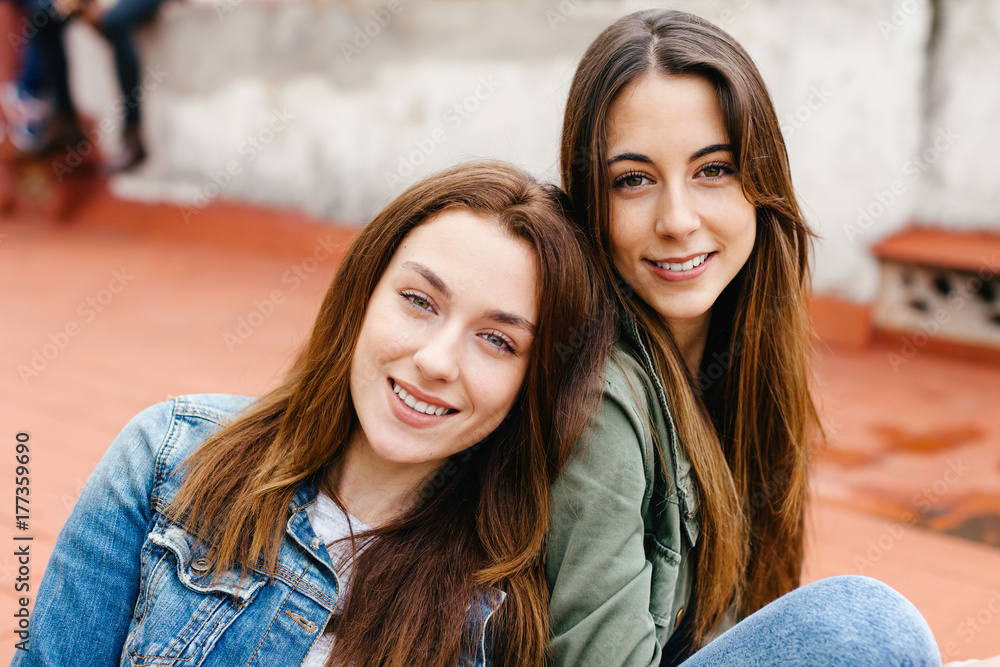 Two young female sitting in outdoors. Two young female sitting in outdoors.
