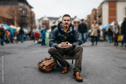 Man Sitting on an Armchair in a Flea Market photo