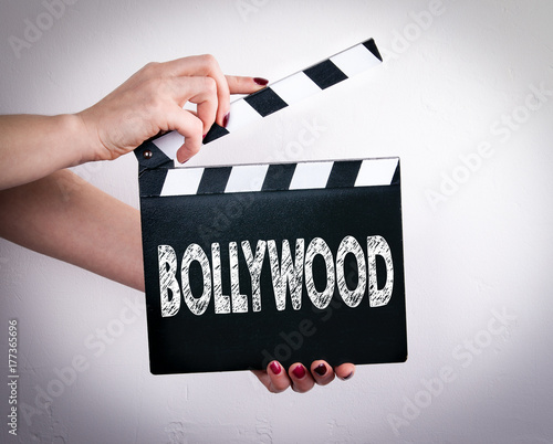 Bollywood. Female hands holding movie clapper. white background