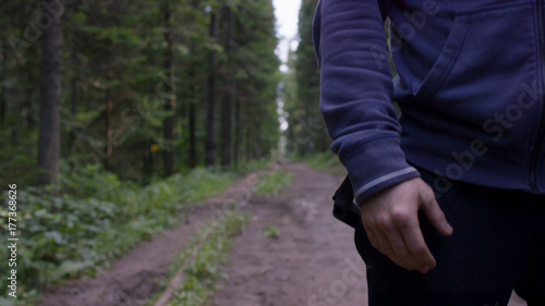 Athlete on road through forest. Athletic man on road through forest. Athletic man standing on trail through autumn forest