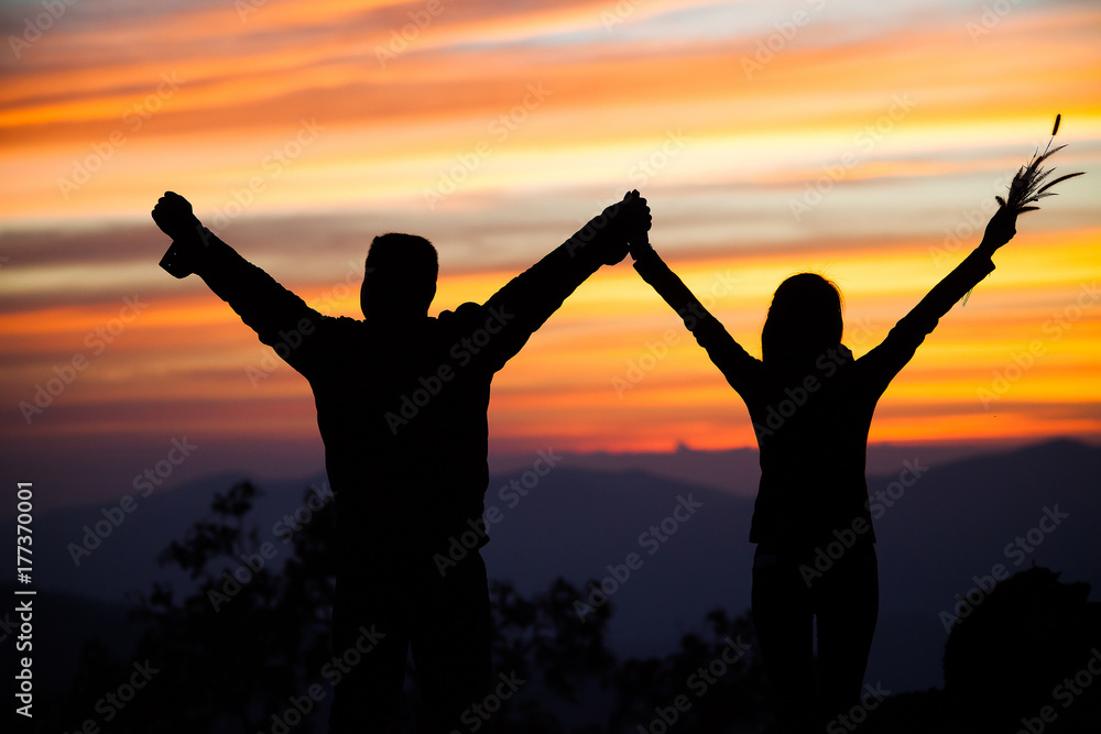 Fototapeta premium Loving couple showing heart symbol on hands,twilight background