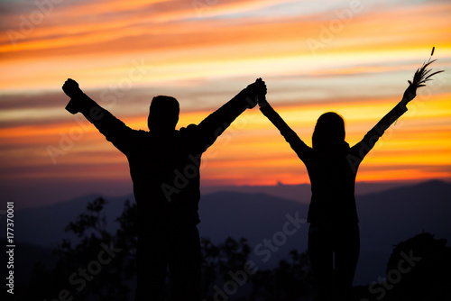 Loving couple showing heart symbol on hands,twilight background