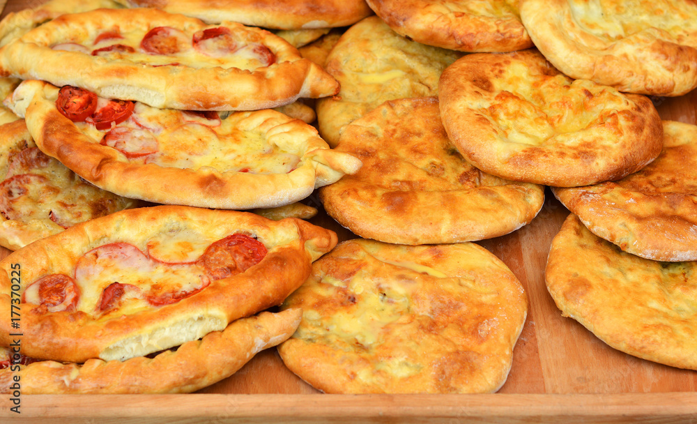 Adjarian khachapuri and kubdari on the wooden table. Khachapuri in Adjarian. Adjarian khachapuri and kubdari on the wooden table. Khachapuri in Adjarian.