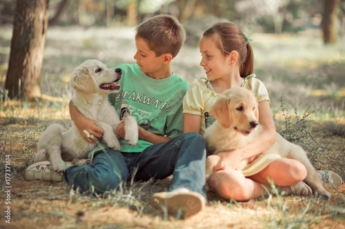 Retriever pup Lovely scene young teen sister brother enjoy posing summer time vacation with best friend dog ivory white labrador puppy.Happy airily careless childhood family life world dreams puppies. photo