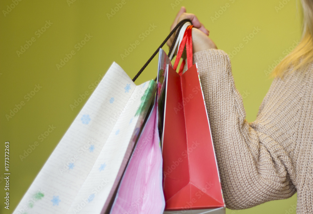girl holds over the shoulder shopping bags