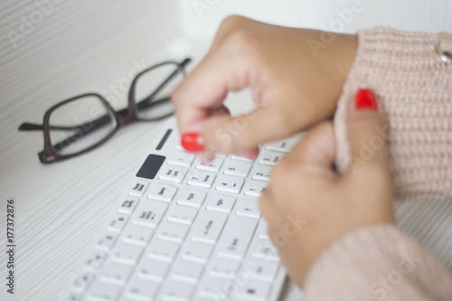 Female hands typing on white computer keyboard