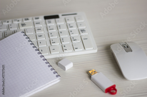 white keyboard, mouse, Notepad, flash card on a white table. business concept