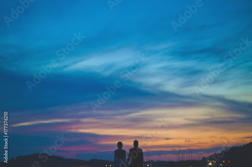 Love couple looking at the sunset photo