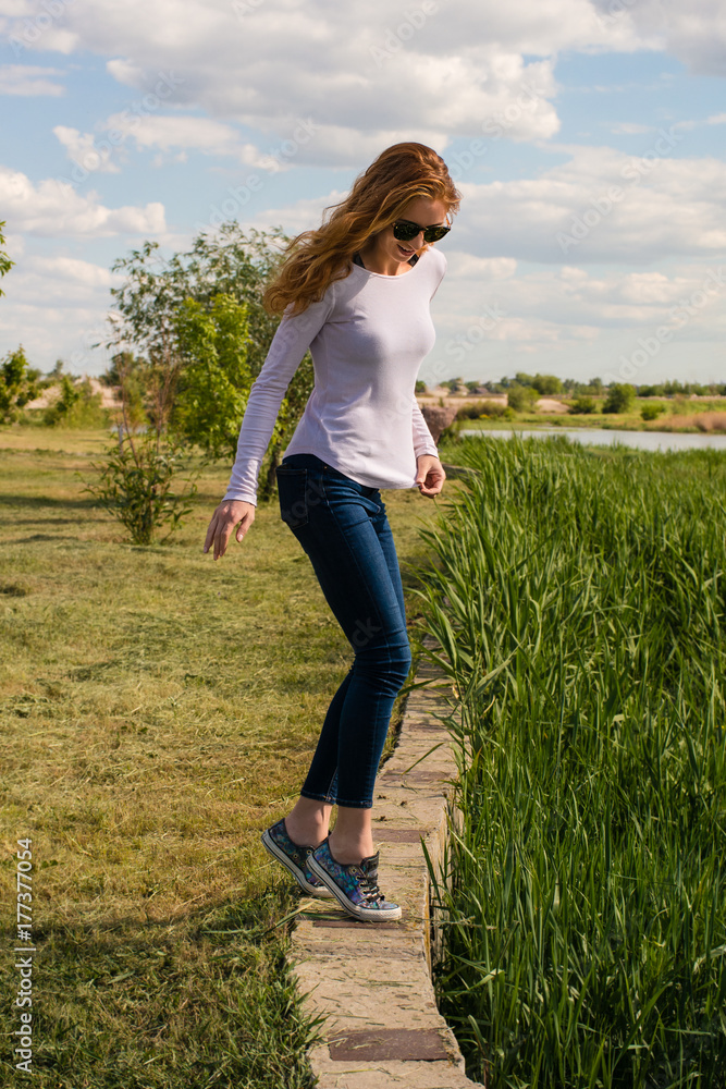 redheaded model is teetering on the parapet redheaded model is teetering on the parapet