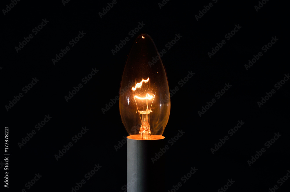 Metalowy żarnik w żarówce świecące w ciemności. - obrazy, fototapety, plakaty 