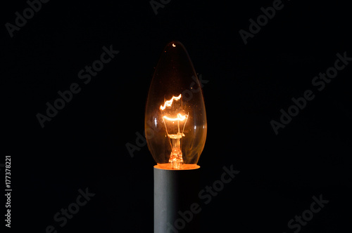 Metalowy żarnik w żarówce świecące w ciemności.