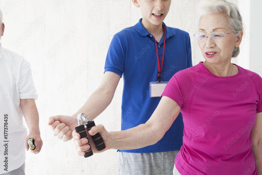 An old couple is exercising grip strength with a trainer An old couple is exercising grip strength with a trainer