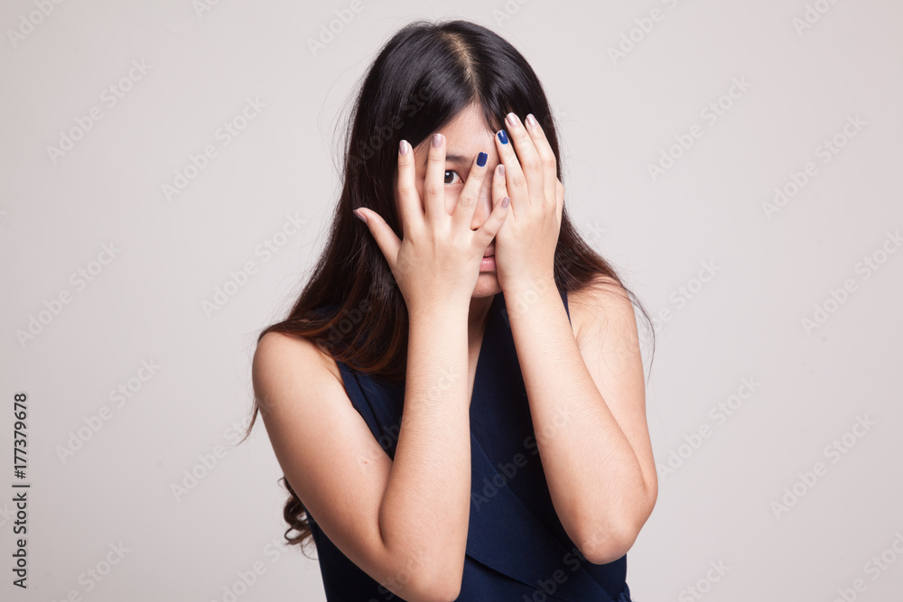 Beautiful young Asian woman peeking through fingers. Beautiful young Asian woman peeking through fingers.