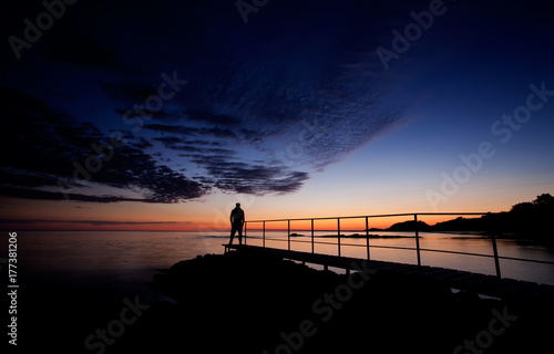 Man on a boardwalk looking at beautiful view on sea, dusk or golden hour at bulgarian Black sea