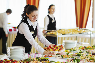 Restaurant waitress serving table with food