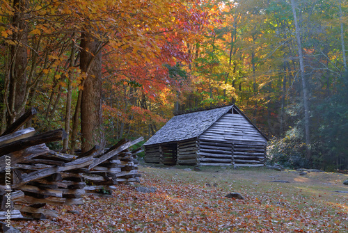 Log barn and split rail fence with colorful fall foliage