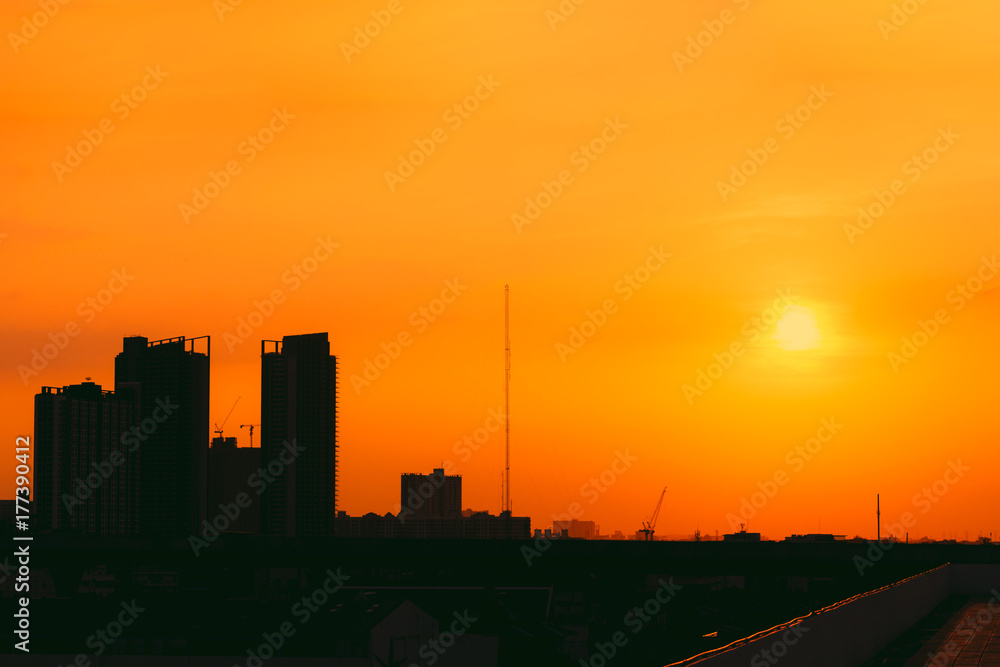 city metro silhouette on sunny orange sunset sky