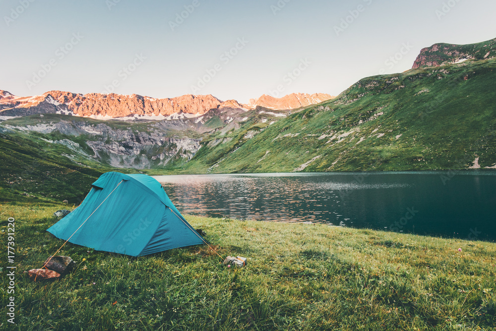 Tent camping at sunset Mountains and lake Landscape Travel Lifestyle concept Summer adventure recreation vacations outdoor