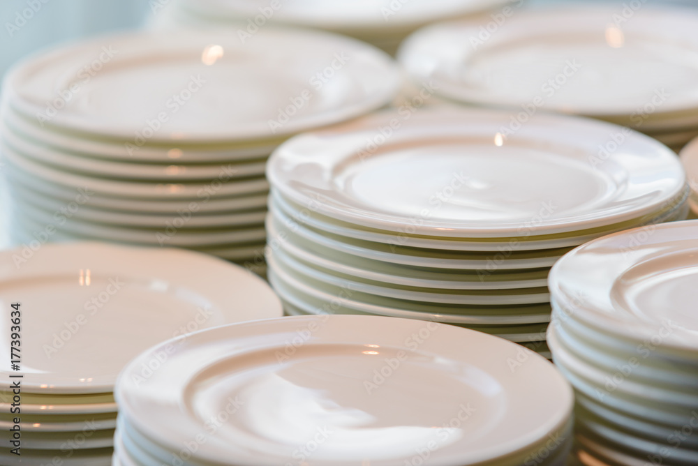 Stacks of cleaned white plates for catering buffet in restaurant room Stacks of cleaned white plates for catering buffet in restaurant room