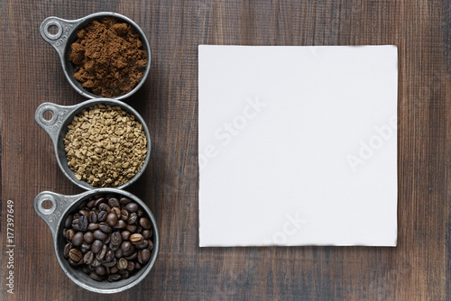 Different types of coffee and paper cadd on a wooden background