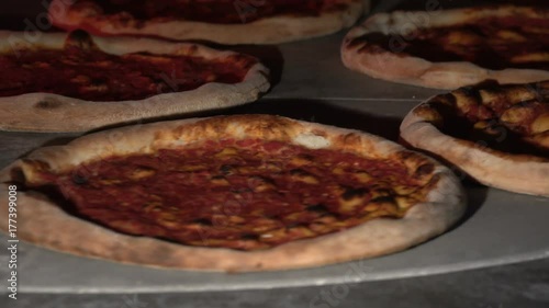 4K video footage of rotating cooking pizza inside the oven. Many pizza rotate in stove photo