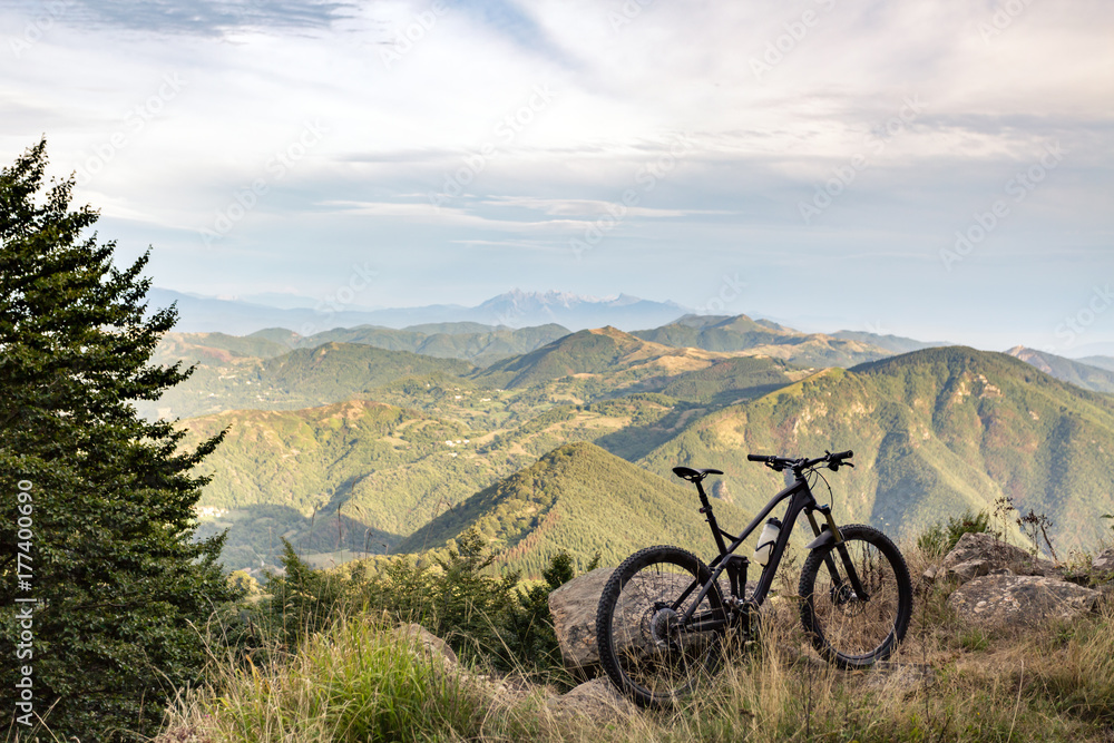 Obraz premium Mountain bike sunset silhouette on forest trail, inspiring landscape