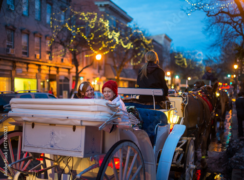 Family Horse Carriage Ride Through Decorated City photo