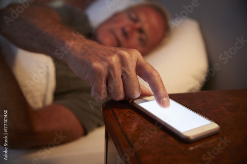 Sleepless Senior Man In Bed At Night Checking Mobile Phone © Monkey Business
