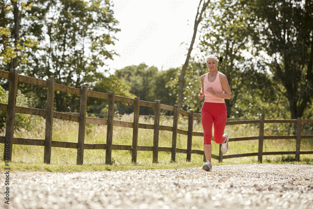 Healthy Senior Woman Enjoying Run Through Countryside