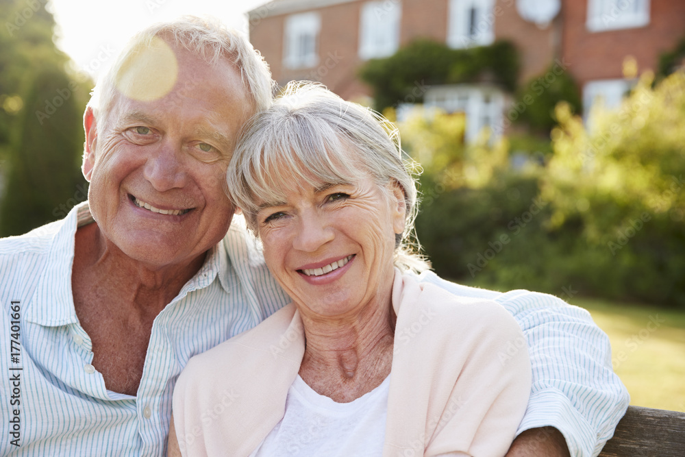 Senior Couple Sitting On Garden Bench In Evening Sunlight Senior Couple Sitting On Garden Bench In Evening Sunlight