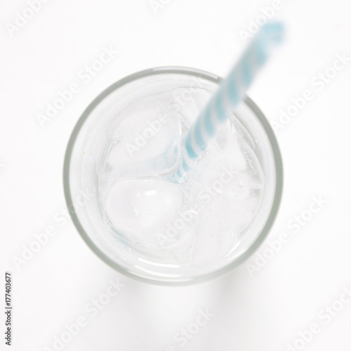 glass with ice cubes on white painted table