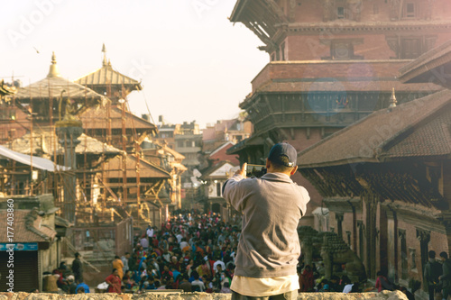 unknown guy taking picture of crowd at Patan Durbar Square by his smart phone photo
